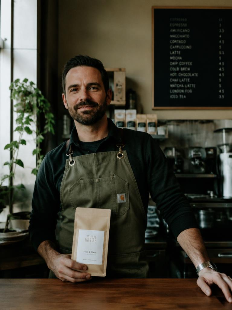 Retrato de marca: dono de cafeteria segurando pacote de café